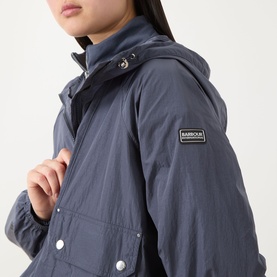 Model wearing Barbour International Maizy Showerproof Jacket in Odyssey, showing logo badge, snap button pocket and elasticated cuff detail.