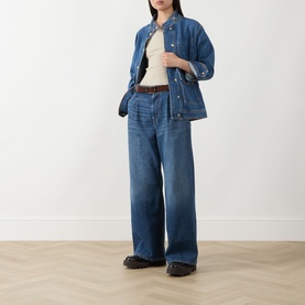Model wearing Barbour International Nikki Biker Denim Jacket in Denim Blue, styled with wide-leg jeans, cream top, and brown belt.