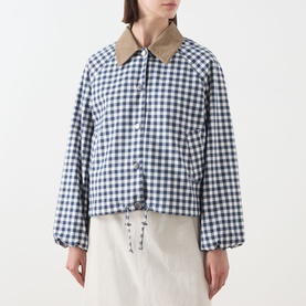 Model wearing Barbour Ovingham Gingham Print Jacket in Navy/Neutral with corduroy collar, blouson sleeves and drawcord hem, styled with white skirt.