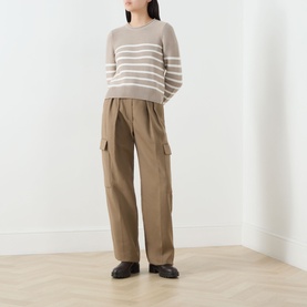 Model wearing Barbour Hinton Striped Knitted Sweater in Light Sand Stripe, cropped length, styled with khaki cargo trousers and black loafers.