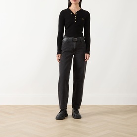 Model wearing Barbour International Kyla Logo Rib-Knit Sweater in black with dark wash jeans and black leather shoes.