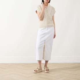 Model wearing Barbour International Light Stone cotton open-knit zip-neck vest, styled with white midi skirt and beige platform sandals.