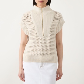 Model wearing Barbour International Light Stone open-knit cotton vest with half-zip neckline, styled with white trousers
