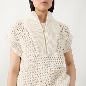 Model wearing Barbour International Light Stone cotton knit vest with open crochet texture, zip neckline, and gold-tone zip detail