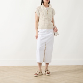 Model wearing Barbour International Light Stone cotton crochet knit vest, styled with white midi skirt and platform sandals.