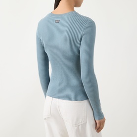 Model wearing Barbour International Seren Rib-Knit Sweater in Washed Pearl Blue, rear view showing rib-knit texture, logo badge and long sleeves.