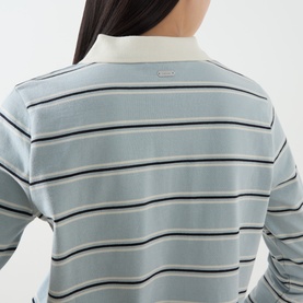 Model wearing Barbour Ashwell Logo Striped Polo Shirt in Celestial Blue Stripe, showing rear logo plaque and striped pattern detail.