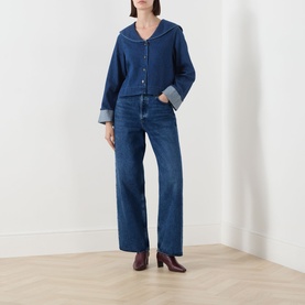 Model wearing Barbour Dartmoor Denim Shirt in Mid Wash Indigo with shawl collar and turned-up cuffs, styled with wide-leg jeans and burgundy heels
