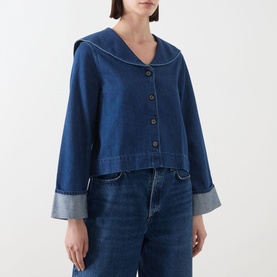 Model wearing Barbour Dartmoor Denim Shirt in Mid Wash Indigo with shawl collar, button front, and turned-up cuffs, styled with matching denim jeans