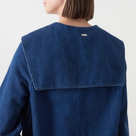 Model wearing Barbour Dartmoor Denim Shirt in Mid Wash Indigo, showing rear view with shawl collar yoke detail and logo plate.