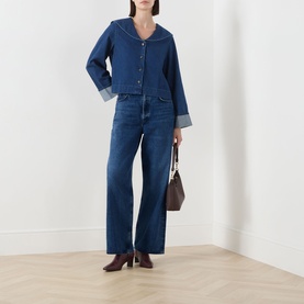 Model wearing Barbour Dartmoor Denim Shirt in Mid Wash Indigo with shawl collar and turned-up cuffs, styled with wide-leg jeans and brown heeled boots
