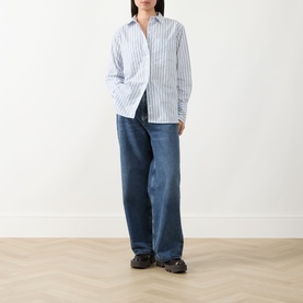 Model wearing Barbour Fawley Striped Shirt in Celestial Blue Folkstone Stripe, styled with wide-leg blue jeans and black chunky sandals.