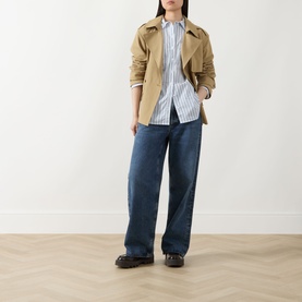 Model wearing Barbour Fawley Striped Shirt in Celestial Blue Folkstone Stripe, styled with camel jacket, wide-leg jeans and black loafers.
