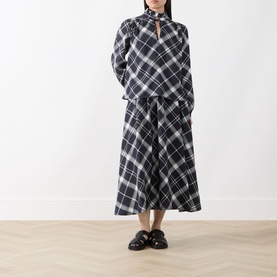 Model wearing Barbour Bailton Tartan Skirt in Dark Navy/White Check, midi-length flared silhouette, styled with matching tartan top and black loafers