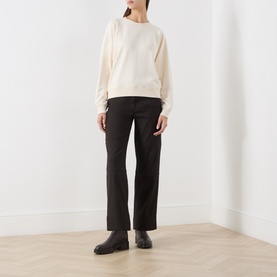 Model wearing Barbour Ecru Sweat Top in cotton, styled with dark wide-leg trousers and black ankle boots