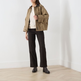 Model wearing Barbour Ecru Sweat Top in cotton, styled with khaki utility jacket, dark flared trousers and brown Chelsea boots