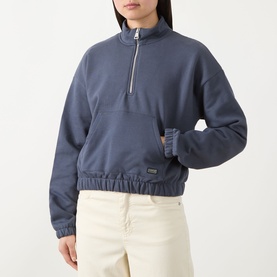 Model wearing Barbour International sweat in Odyssey blue, half-zip funnel neck, elasticated hem, small logo badge, styled with cream trousers