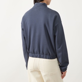 Model wearing Barbour International sweat in Odyssey blue, back view, half-zip funnel neck, elasticated hem, styled with cream trousers