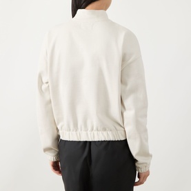 Model wearing Barbour International light stone cotton sweat top, rear view, with black trousers. Ribbed hem and cuffs, mock neck collar.