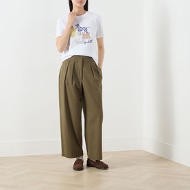 Model wearing Barbour Fawley Dogs Logo T-Shirt in white with khaki wide-leg trousers and brown loafers.