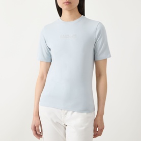Model wearing Barbour International Pearl Blue cotton T-shirt with subtle logo embroidery, styled with white trousers.