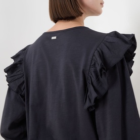 Model wearing Barbour Carleen Ruffled Blouse in Dark Navy, showing rear view with ruffle shoulder detailing and logo plate at back