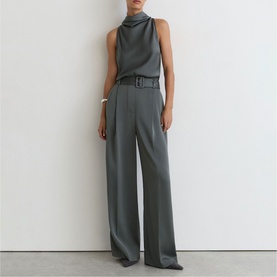 Model wearing Reiss dark grey sleeveless high-neck top and wide-leg belted trousers, styled with a silver cuff bracelet