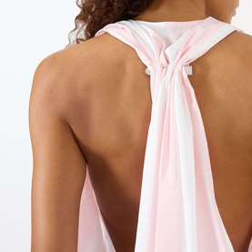 Model wearing Jacquemus shirt in light pink and white jacquard big stripes, open back with gathered knot and pin detail at nape
