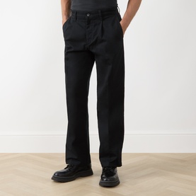 Model wearing Levi's Pleated Work Chinos in Mineral Black Twill, slim-leg fit with front pleats and pressed creases, styled with black leather shoes.