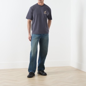 Model wearing Levi's Crew Neck T in periscope grey with small chest graphic, styled with wide-leg blue jeans and black shoes
