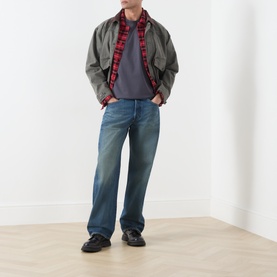 Model wearing Levis Crew Neck T in Periscope grey, styled with olive jacket, red plaid shirt, and mid-wash blue jeans.