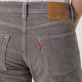 Model wearing Levis 555&trade; Corduroy Relaxed Straight Jeans in Smokey Taupe, showing rear pockets, red tab logo and leather patch detail.