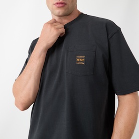Model wearing Levis Workwear Pocket Logo T-Shirt in Jet Black, showing chest patch pocket with gold logo badge detail.