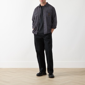 Model wearing Levi's Workwear Pocket Logo T-Shirt in Jet Black, styled with a grey overshirt and black trousers.