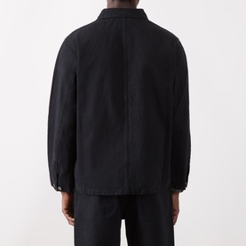 Model wearing Nudie Jeans black cotton casual jacket, rear view, shown with matching black trousers