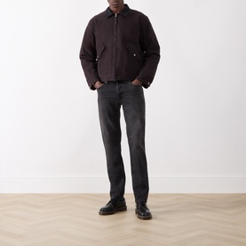 Model wearing Nudie Jeans Dark Brown cotton casual jacket with zip collar, styled with grey jeans and black leather shoes.