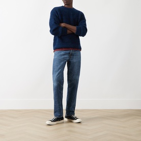 Model wearing Nudie Jeans Gurra Boucle Sweater in R22 Multi, crew neck, styled with mid-wash straight-leg jeans and black high-top trainers.
