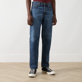 Model wearing Nudie Jeans Rad Rufus Straight-Leg Jeans in Blue Twisted Tracks, mid-wash rigid denim, styled with black high-top trainers.