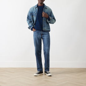 Model wearing Nudie Jeans Rad Rufus Straight-Leg Jeans in Blue Twisted Tracks, styled with a denim jacket, navy tee, and black trainers.