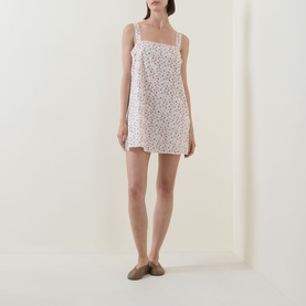 Model wearing Posse Watercolour Floral mini dress in white cotton with square neckline and thin straps, styled with tan flat mules.