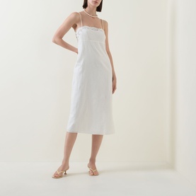 Model wearing Posse cream linen-cotton slip dress with thin straps and mesh neckline detail, styled with nude heeled mules