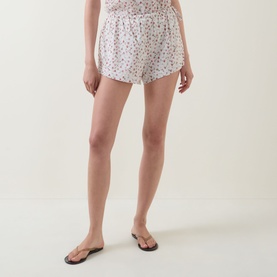 Model wearing Posse Watercolour Floral cotton shorts with matching cami top and black flat sandals.