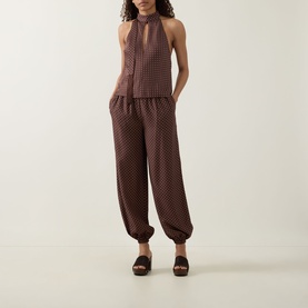Model wearing Posse Phoebe Polka Dot Blouse in Choc Vanilla with matching polka dot trousers and dark flatform sandals.