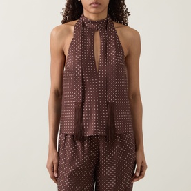 Model wearing Posse Phoebe Polka Dot Blouse in Choc Vanilla, halterneck with scarf detail and fringing, styled with matching trousers