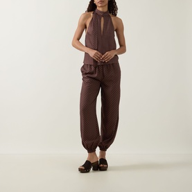 Model wearing Posse Evie Polka Dot Trousers in Choc Vanilla with matching halterneck top and brown clogs.