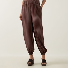 Model wearing Posse Evie Polka Dot Trousers in Choc Vanilla, balloon-leg silhouette with cuffed hems and elasticated waist, styled with black mule