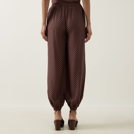 Model wearing Posse Evie Polka Dot Trousers in Choc Vanilla, balloon-leg silhouette with cuffed hems, styled with brown mules.