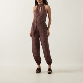 Model wearing Posse Evie Polka Dot Trousers in Choc Vanilla, balloon-leg with cuffed hems, styled with matching halterneck top and platform sandals.