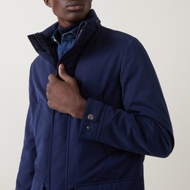 Model wearing B Cucinelli navy casual jacket with layered collar detail, styled over a blue shirt.