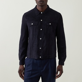 Model wearing B Cucinelli navy calf suede casual jacket with snap buttons and chest pockets, styled with blue trousers
